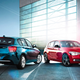 Two BMW 1 Series cars parked by a hanger